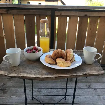 a table with a plate of pastries and a bowl of fruit at LAKE HOUSE BOHINJ in Bohinj