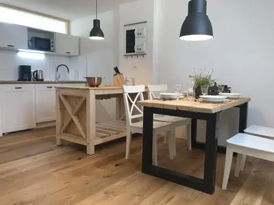 a kitchen with a wooden table and a dining room at LAKE HOUSE BOHINJ in Bohinj