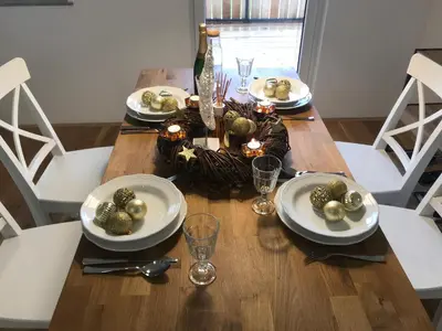 a dining room table with white plates and a christmas centerpiece at LAKE HOUSE BOHINJ in Bohinj