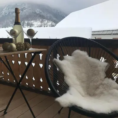 a table and chairs with a bottle of wine on a balcony at LAKE HOUSE BOHINJ in Bohinj