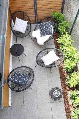 a patio with four chairs and tables with pillows at Lusht'n apartma in Žirovnica