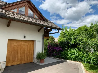 a house with a wooden garage door at Lusht'n apartma in Žirovnica
