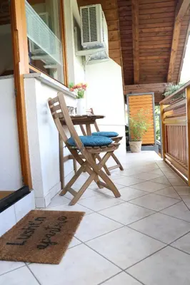 a patio with a table and a chair on a porch at Lusht'n apartma in Žirovnica