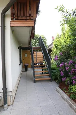 a stairway leading up to a house with a wooden railing at Lusht'n apartma in Žirovnica