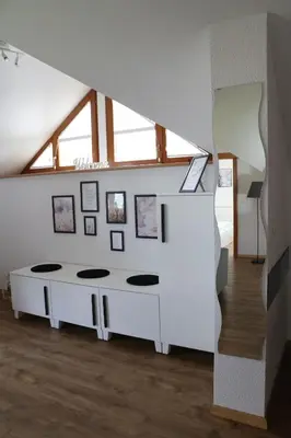 a living room with a white table in a attic at Lusht'n apartma in Žirovnica