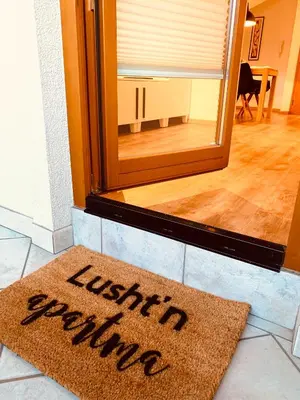 a welcome mat on the floor in front of a mirror at Lusht'n apartma in Žirovnica