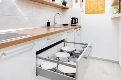 a kitchen with white cabinets and a sink at Apartments Julian Adventure in Kranjska Gora