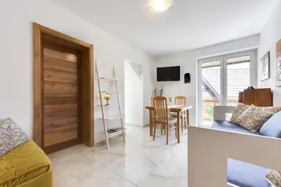 a living room with a couch and a dining room at Apartments Julian Adventure in Kranjska Gora