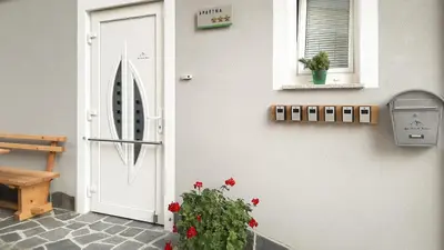a door and a plant next to a building at Apartments Julian Adventure in Kranjska Gora