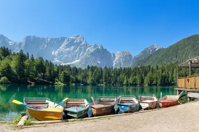 a group of boats sitting on the shore of a lake at Apartments Julian Adventure in Kranjska Gora