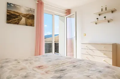 a bedroom with a bed with a large window at Sunset Apartments Bohinj in Bohinj