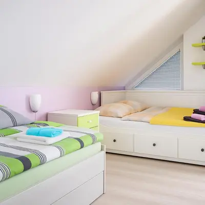 two beds in a room with white cabinets at Sunset Apartments Bohinj in Bohinj