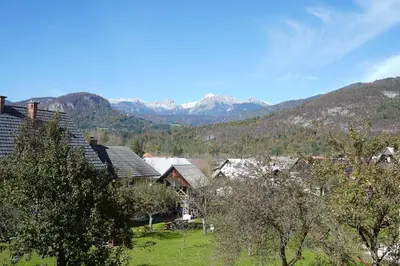a group of houses with mountains in the background at Sunset Apartments Bohinj in Bohinj