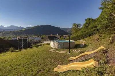 a backyard with a hot tub and a slide at Sunset Apartments Bohinj in Bohinj