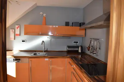 a kitchen with orange cabinets and a sink at Sunset Apartments Bohinj in Bohinj