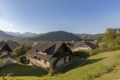 an aerial view of a house with mountains in the background at Sunset Apartments Bohinj in Bohinj