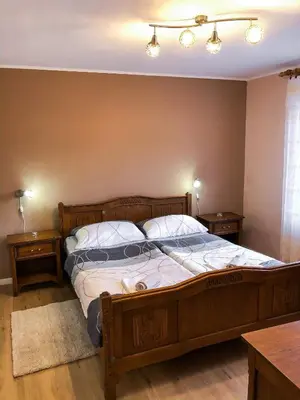 a bedroom with a large wooden bed with two night stands at Apartma Bubi in Bovec