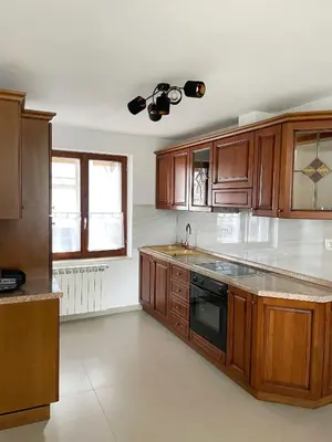 a kitchen with wooden cabinets and a stove top oven at Apartma Bubi in Bovec