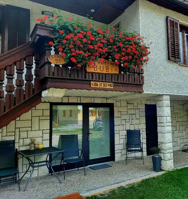 a building with a table and chairs and a balcony with flowers at Apartma Bubi in Bovec