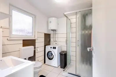 a bathroom with a toilet and a washing machine at Casa Badiha in Zgornje Škofije
