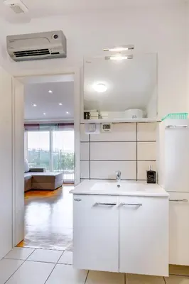 a kitchen with white appliances and a living room at Casa Badiha in Zgornje Škofije