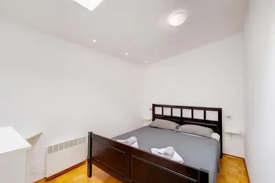 a bedroom with a bed and white walls at Casa Badiha in Zgornje Škofije