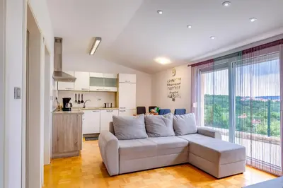 a living room with a couch and a kitchen at Casa Badiha in Zgornje Škofije