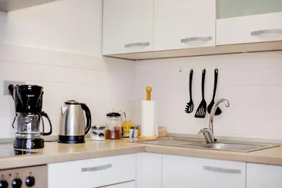 a kitchen with white cabinets and a sink at Casa Badiha in Zgornje Škofije