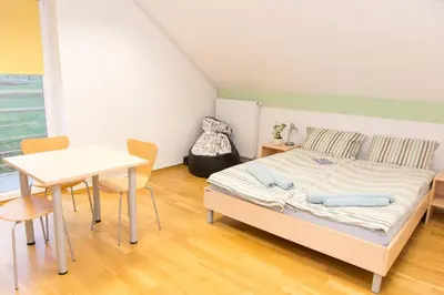 a small bedroom with a bed and a table at Apartma Murania in Lendava