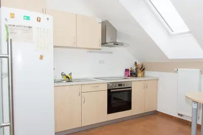 a kitchen with white cabinets and a skylight at Apartma Murania in Lendava