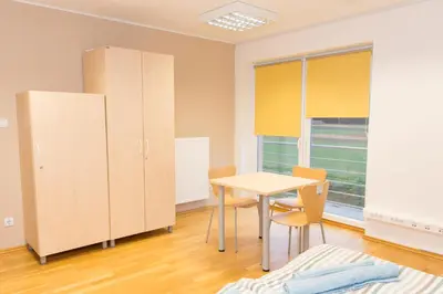 a room with a table and chairs and a large window at Apartma Murania in Lendava