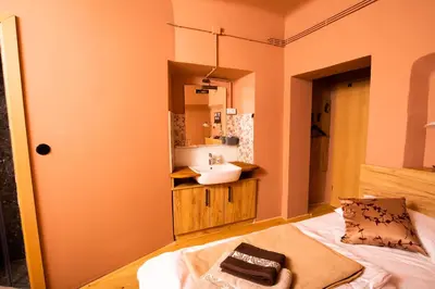 a bathroom with a sink and a bed in a room at Dežnik in Ljubljana