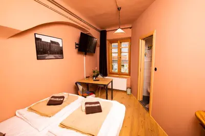 a room with two beds and a table in it at Dežnik in Ljubljana