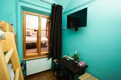 a room with a blue wall with a window and a table at Dežnik in Ljubljana