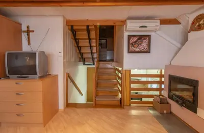 a tiny house with a staircase and a tv at Vineyard cottage Hočevar in Novo Mesto