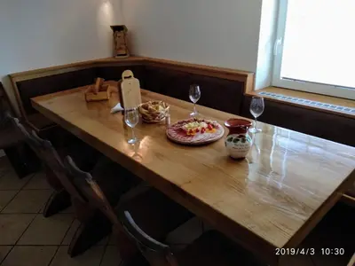 a wooden table with a plate of food and wine glasses at Vineyard cottage Hočevar in Novo Mesto