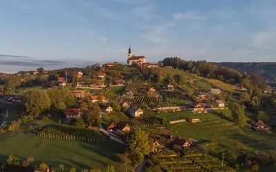 a small village on a hill with a church on it at Vineyard cottage Hočevar in Novo Mesto