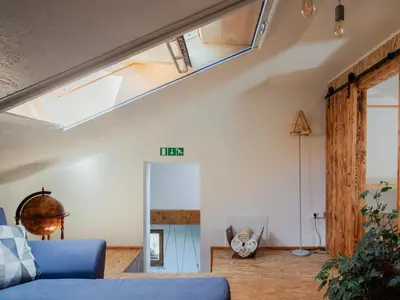 a living room with a blue couch and a skylight at Apartment Vrhouc in Tolmin