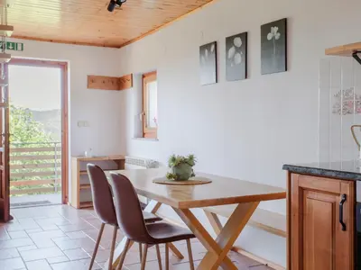a kitchen with a wooden table and chairs at Apartment Vrhouc in Tolmin