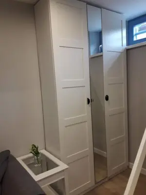 a white closet with a mirror and a couch at Alpine Cottage in Bled