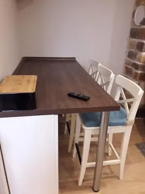 a wooden table with chairs and a remote control on it at Alpine Cottage in Bled
