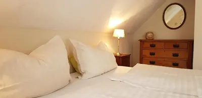 a bedroom with a bed with white pillows and a mirror at The OldMillhouse in Mojstrana