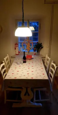 a dining room table with a white table cloth and white chairs at The OldMillhouse in Mojstrana