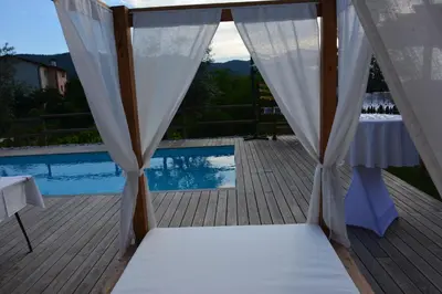 a canopy bed on a deck next to a pool at ČEBRON FAMILY ESTATE in Branik