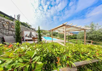 a garden with a swimming pool and a wooden pergola at ČEBRON FAMILY ESTATE in Branik