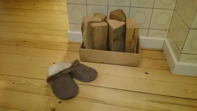 a pair of shoes sitting on the floor next to a block of wood at Bergmannhaus in Zagorje ob Savi