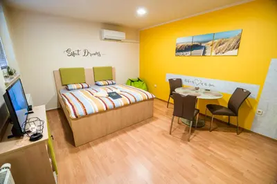 a bedroom with a bed and a table with chairs at Lux Living Apartments BUDIČ near Terme Čatež in Brežice
