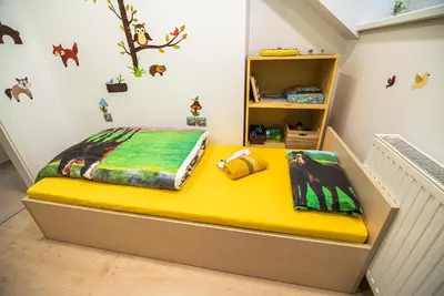 a childs room with a bed with a yellow mattress at Lux Living Apartments BUDIČ near Terme Čatež in Brežice