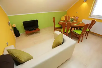a living room with a white couch and a table at Lux Living Apartments BUDIČ near Terme Čatež in Brežice
