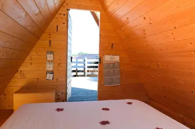 a bedroom with a bed in a wooden cabin at House of Nature Tajhte in Planina pri Sevnici